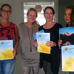 Drie vrouwen tonen elk een certificaat van YogaReiki-cursus